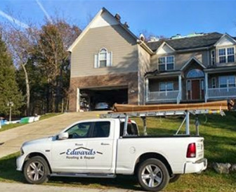 Edwards Roofing and Exteriors truck in front of a home roof repair project
