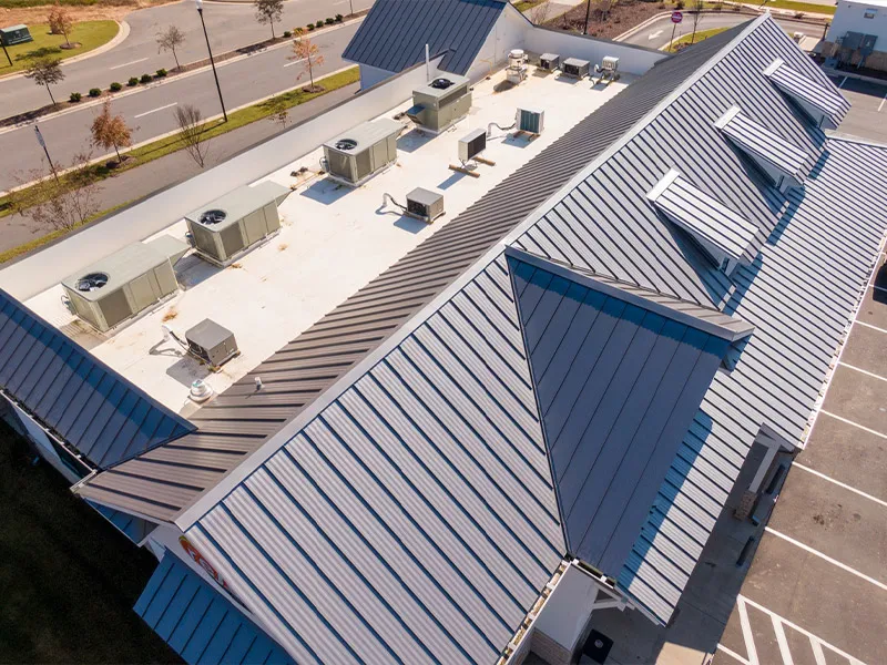 Aerial view of commercial building with metal standing-seam roof and rooftop HVAC units